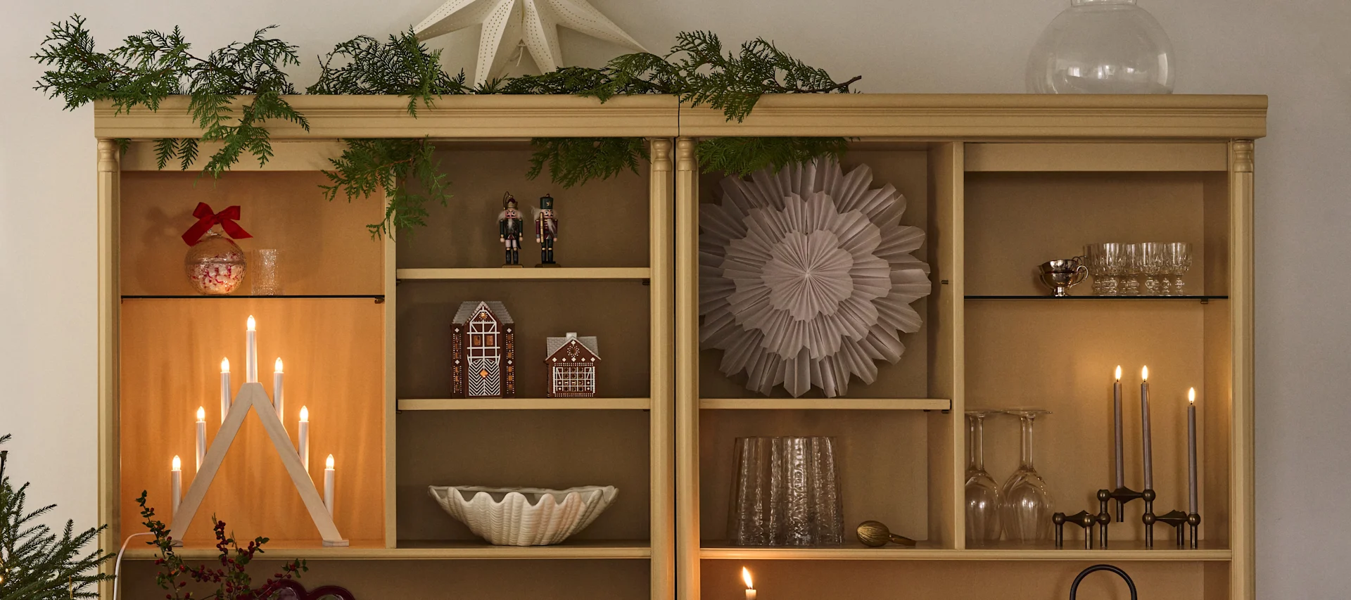 Weihnachtlich dekoriertes Bücherregal mit Weihnachtssternen und Kerzenständer, perfekt, um sich auf den ersten Advent einzustimmen.