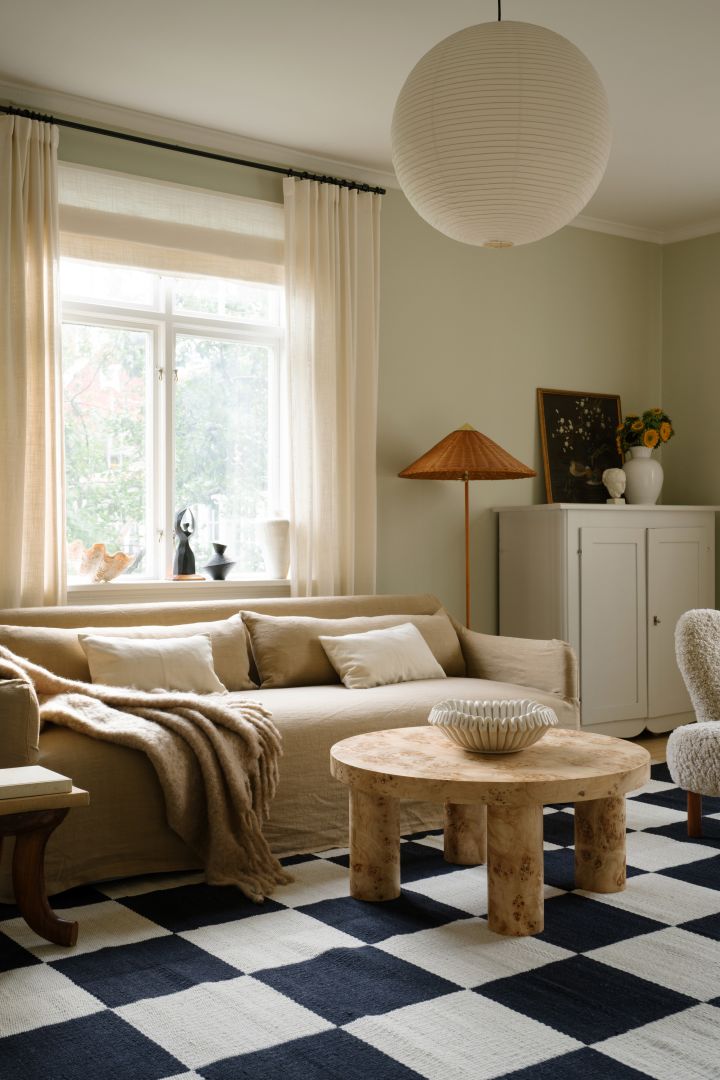 Die richtige Deckenleuchte fürs Wohnzimmer finden: Hier sehen Sie den schlichten Rice Paper Lampenschirm von HAY in einem skandinavisch-modern eingerichteten Wohnzimmer in Beige.