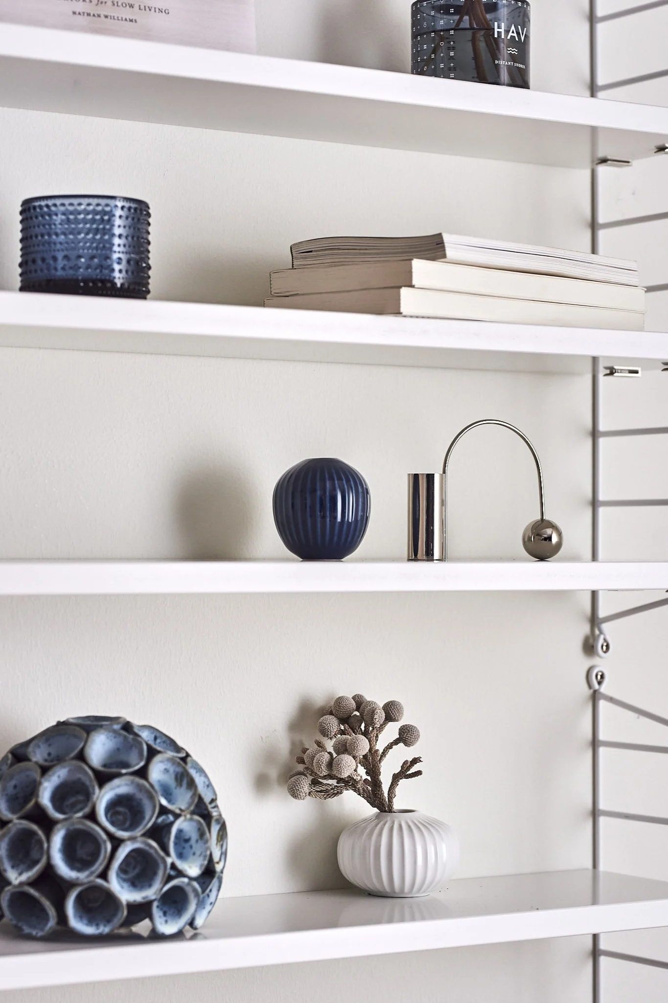 Das String Pocket Regal in Weiß mit blauen Details zeigt, wie man ein Regal im klassischen Look gestalten kann.