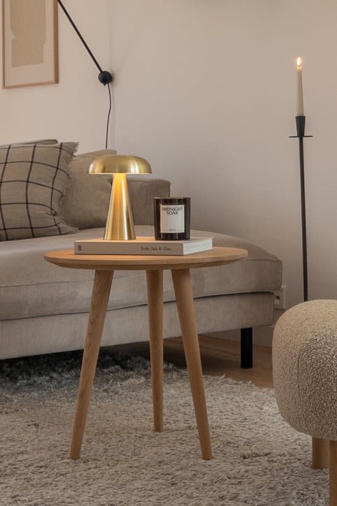 Kreieren Sie ein skandinavisches Zuhause mit @haus_tannenkamp. Hier sehen Sie die tragbare Tischleuchte Como auf einem Beistelltisch aus hellem Holz. 