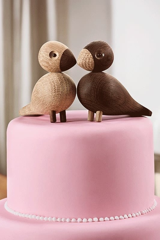 Hochzeitsgeschenk-Ideen: Die Lovebirds von Kay Bojesen stehen auf einer pinken Torte.
