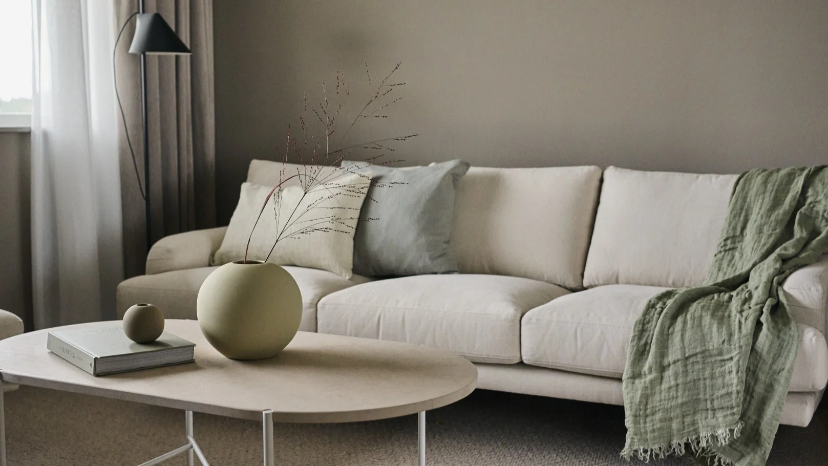 Zwei Versionen der Ball Vase von Cooee Design stehen auf einem Couchtisch in einem skandinavischen Wohnzimmer.