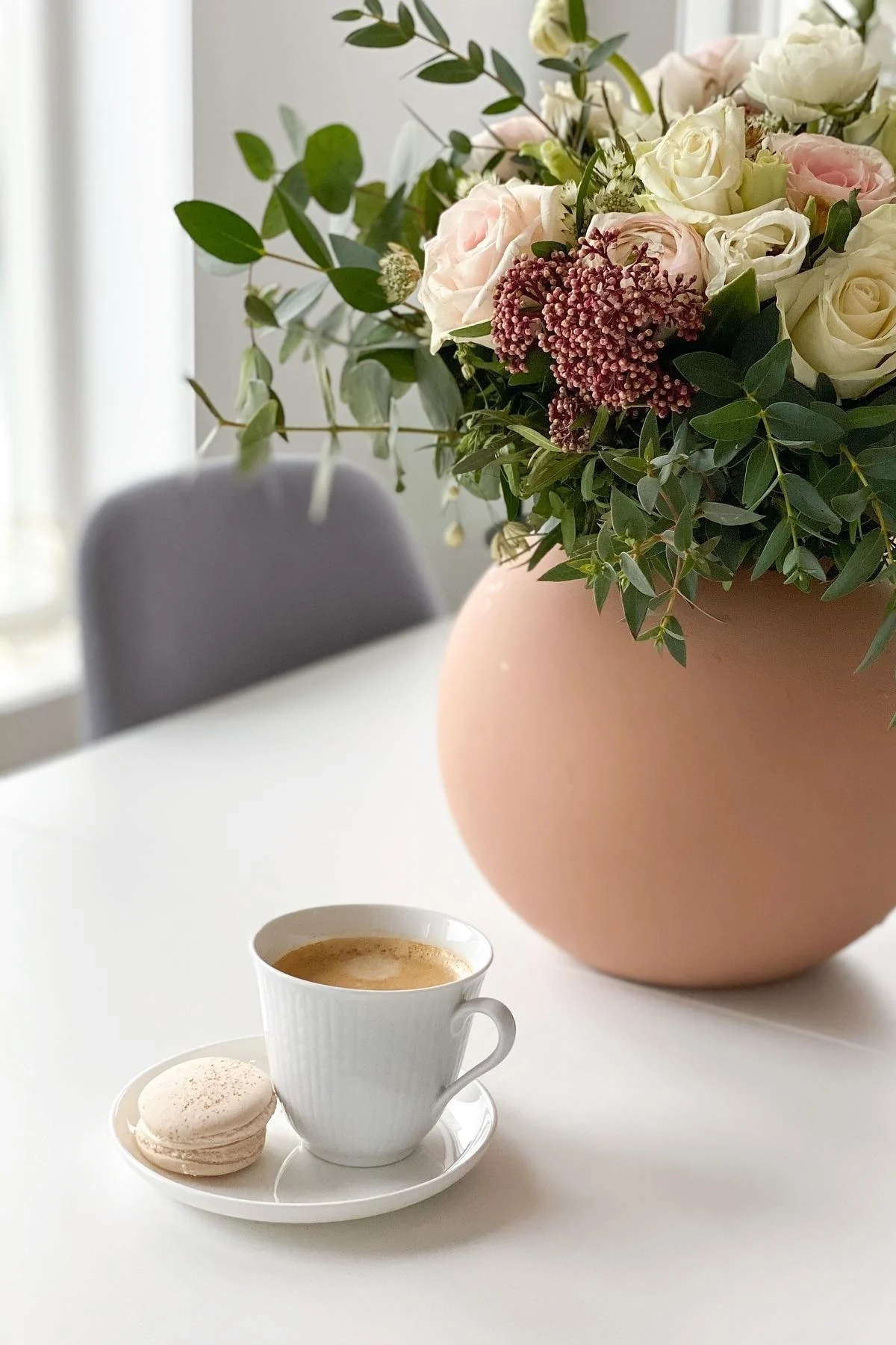 Auf dem Esszisch von @helfag steht ein Kaffee in der kleinen weißen Swedish Grace Tasse von Rörstrand, daneben ein Blumenstrauß in der Ball Vase von Cooee Design.