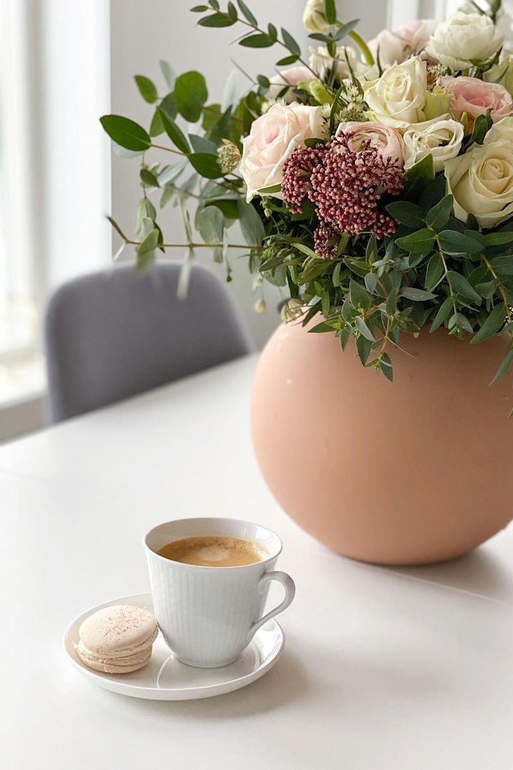 Auf dem Esszisch von @helfag steht ein Kaffee in der kleinen weißen Swedish Grace Tasse von Rörstrand, daneben ein Blumenstrauß in der Ball Vase von Cooee Design.