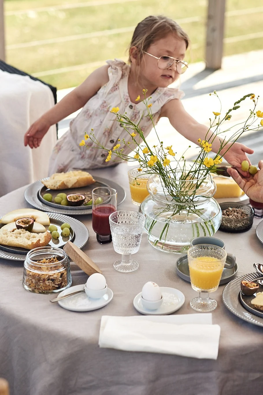 Vorbereitung für das Hotelfrühstück zu Hause mit einer Vase auf dem Tisch und Frühstücksleckereien. 