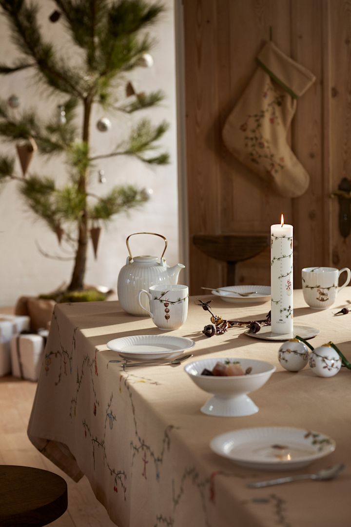 Ein weihnachtlich gedeckter Tisch in Skandinavien mit einer Tischdecke und Weihnachtsgeschirr aus der Hammershøi-Kollektion von Kähler.