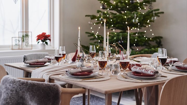 Für das diesjährige Weihnachtsessen ist ein Weihnachtstisch in Rottönen dekoriert.