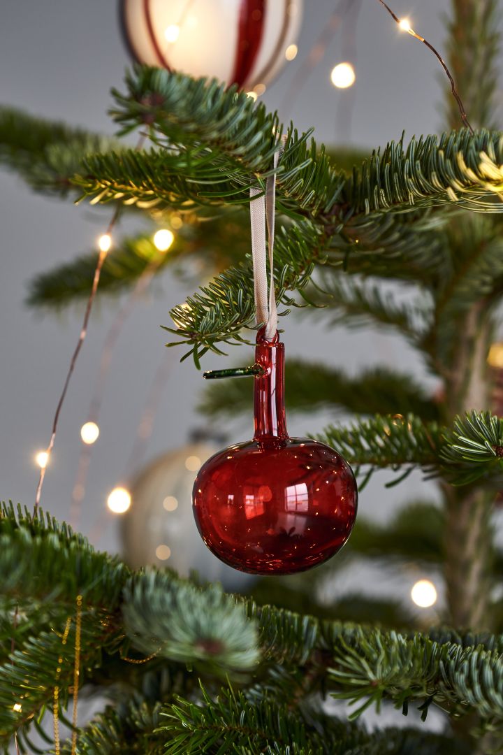 Dekorieren Sie Ihren Baum dieses Jahr mit dem Weihnachtsbaumschmuck 2021 in den 4 verschiedenen Stilen der Nest Trends – Nurture, Share, Boost und Cultivate. Hier sehen Sie den Iittala Glasapfel in Rot.
