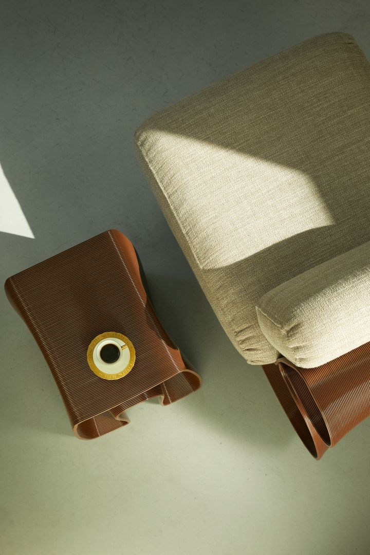 Hier sehen Sie den 3D-gedruckten Eel Lounge Chair und den Octopus Beistelltisch, beide in der Farbe Chocolate. 
