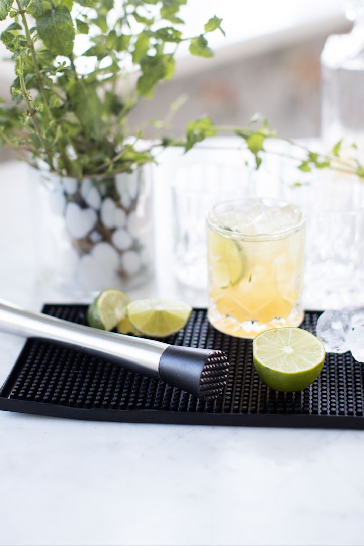 Alkoholfreie Cocktails: Ein Virgin Caipirinha mit Limette und braunem Zucker steht auf einer Barmatte.