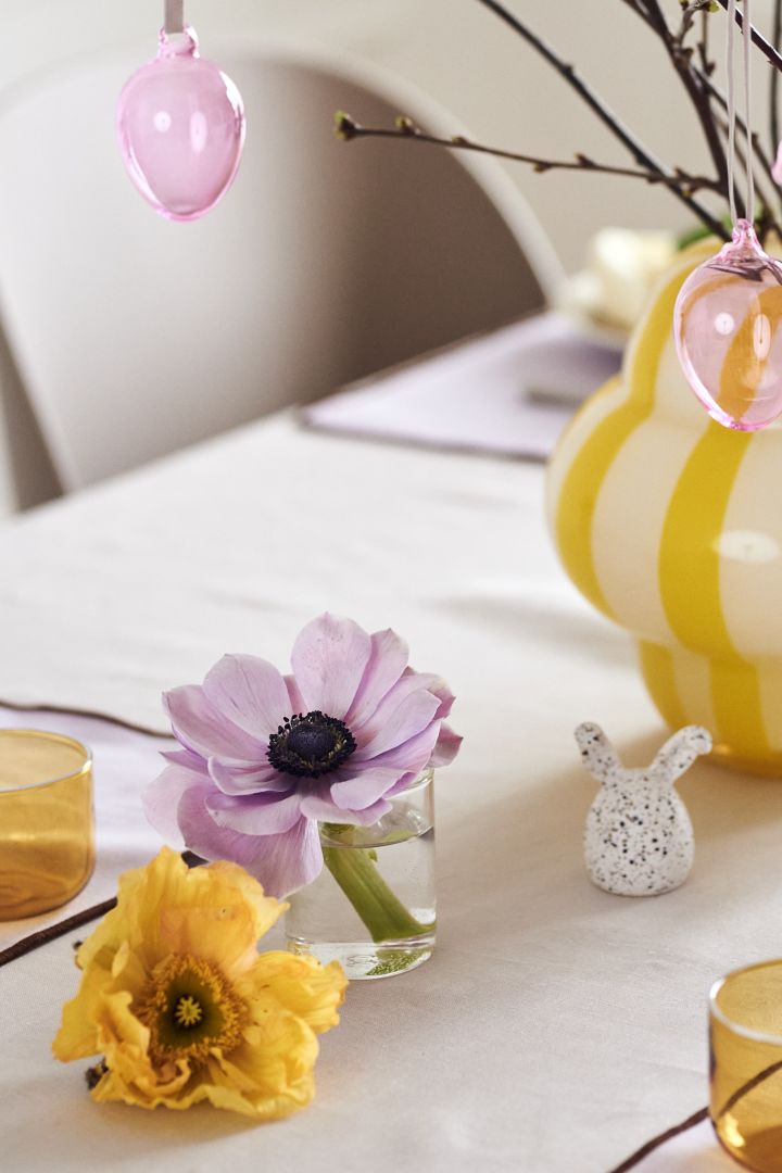 Gestalten Sie einen festlichen Ostertisch in frühlingshaften Pastelltönen mit hübschen Schnittblumen, bunten Glaseiern von Iittala und Osterhasenfiguren von DBKD.