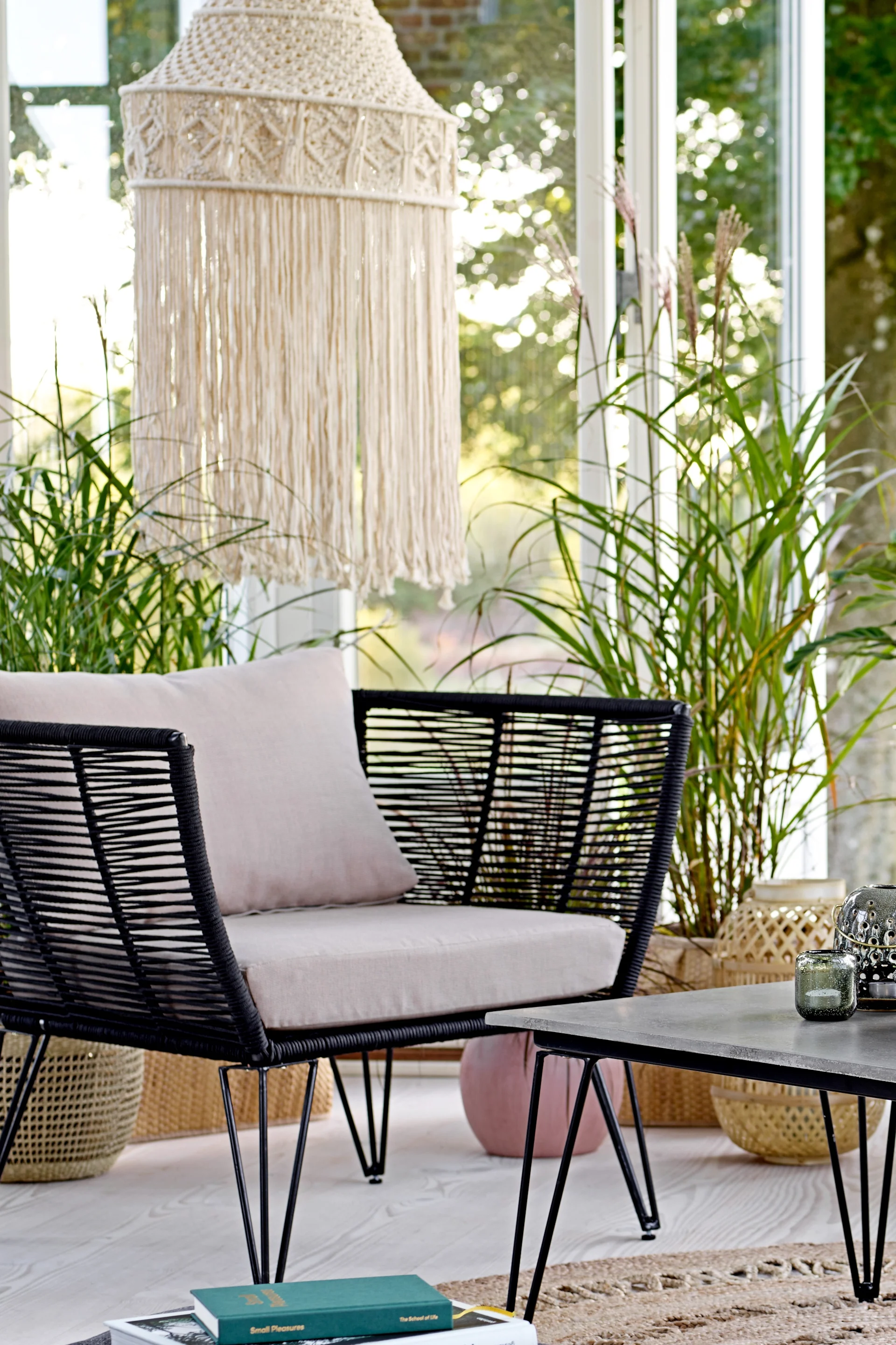 Der Mundo Loungesessel von Bloomingville entspricht der typischen Boho Deko und steht hier in einem offenen Loungebereich.