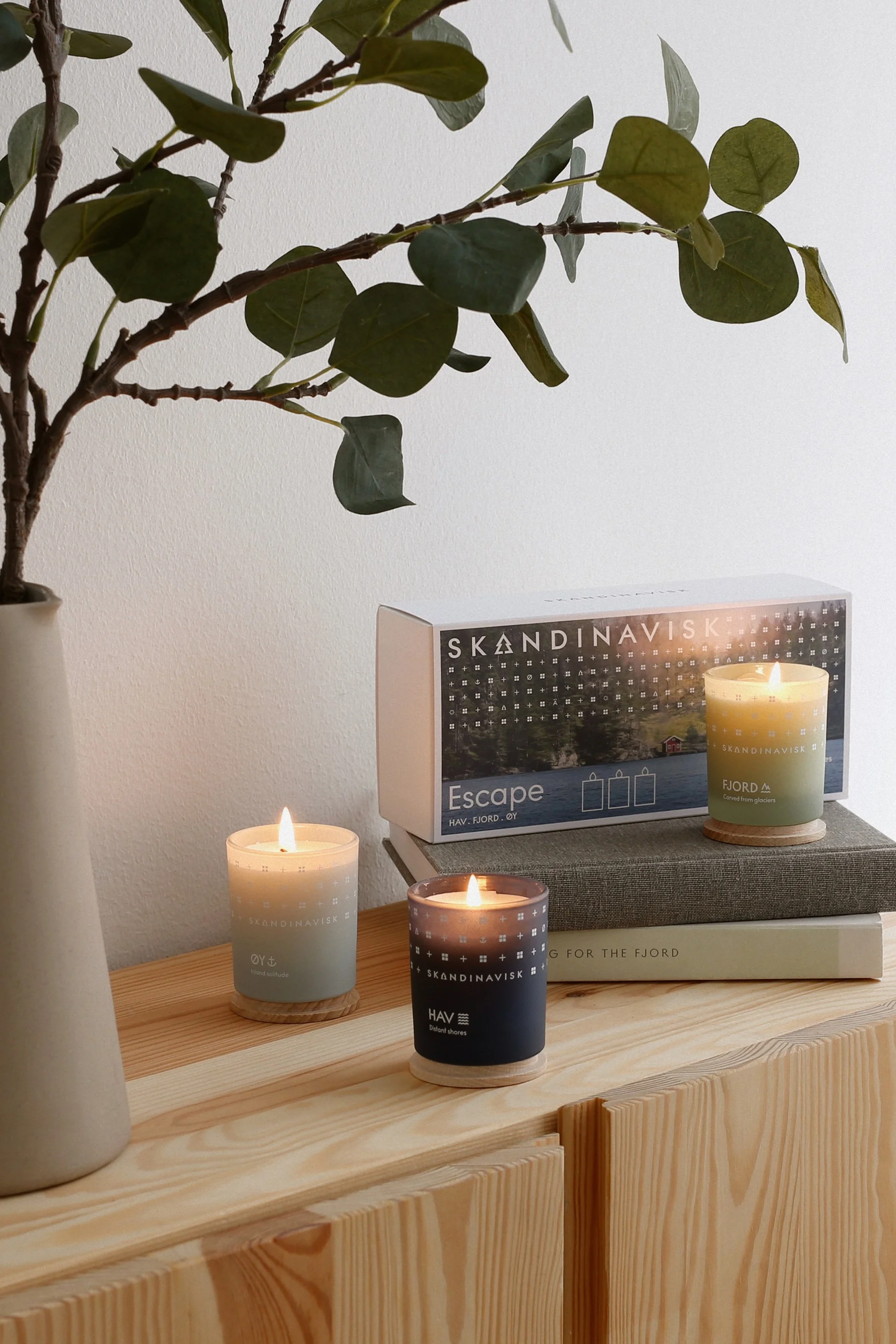 Muttertagsgeschenke: Das dreiteilige Geschenkset Escape von Skandinavisk steht hier dekorativ auf einer Kommode aus Holz.