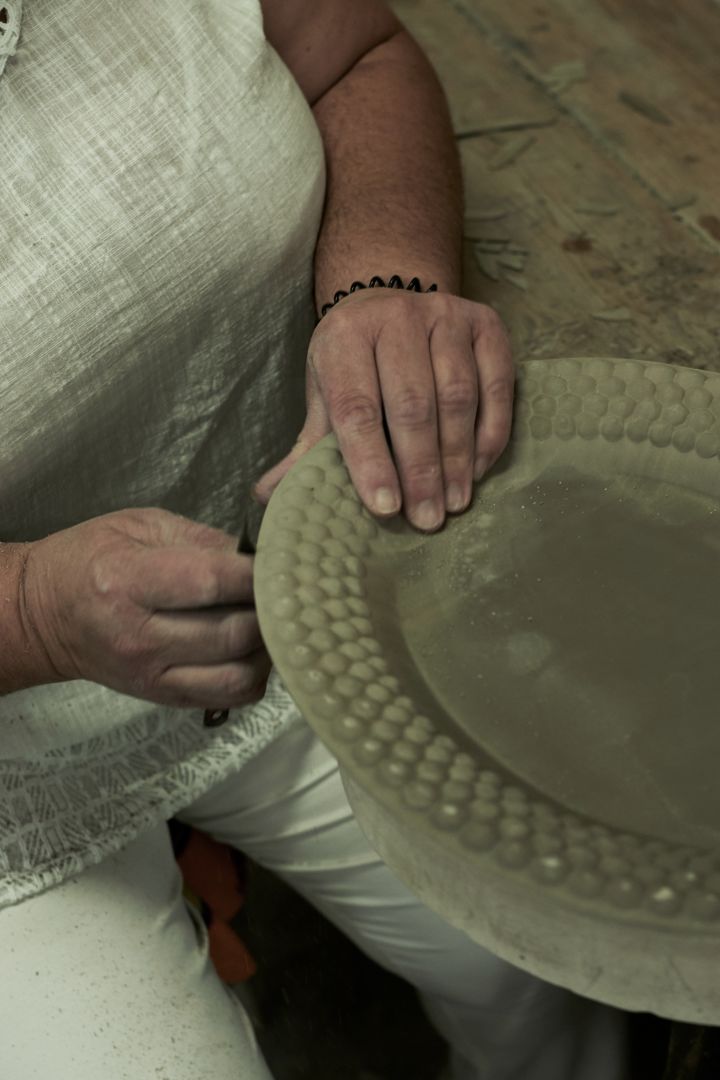 Überschüssiger Ton wird aus der Mateus-Keramik entfernt, was Schritt 3 des Herstellungsprozesses ist.