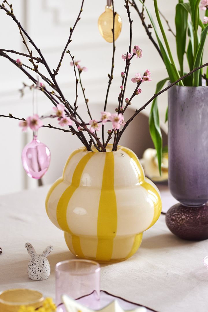 Gestalten Sie einen festlichen Ostertisch Pastellfarben mit bunten Glaseiern von Iittala an einem schönen Osterstrauß in einer Curlie-Vase von By On.