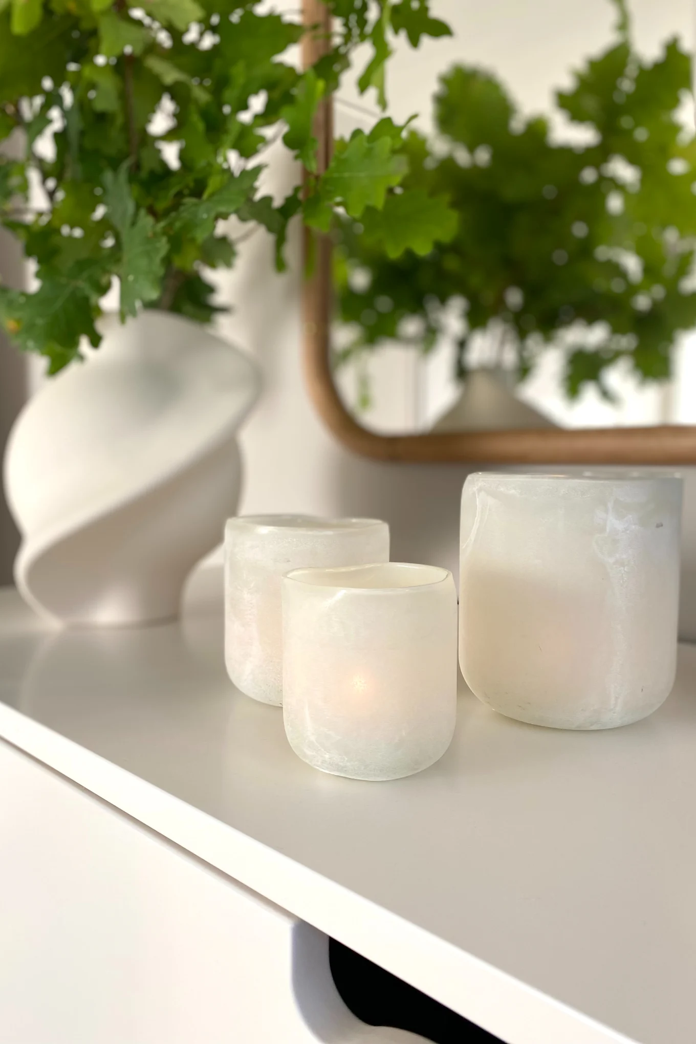 Kreieren Sie ein gemütliches Hygge-Wohnzimmer mit Hilfe von Kerzen und taktilen Vasen wie diesen von Olsson und Jensen.