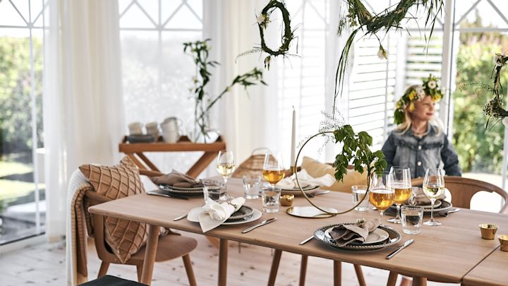 Decken Sie den Tisch für Mittsommer in einem skandinavischen Stil, der das schöne Junilicht mit hellen Holztischen und -stühlen, wogenden Textilien und erdigen Farben einfängt.