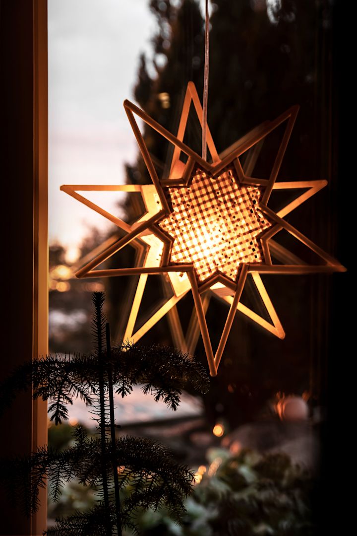 Pour la décoration de Noël scandinave, les étoiles de Noël sont indispensables. Ici, l’étoile de l’Avent Karin de Globen Lighting est suspendue à une fenêtre.