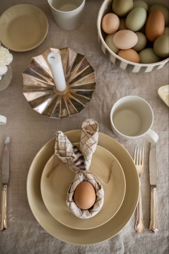 Servietten falten: Binden Sie die Enden der Serviette zusammen, um ein Nest, beispielsweise für ein Osterei, zu schaffen.