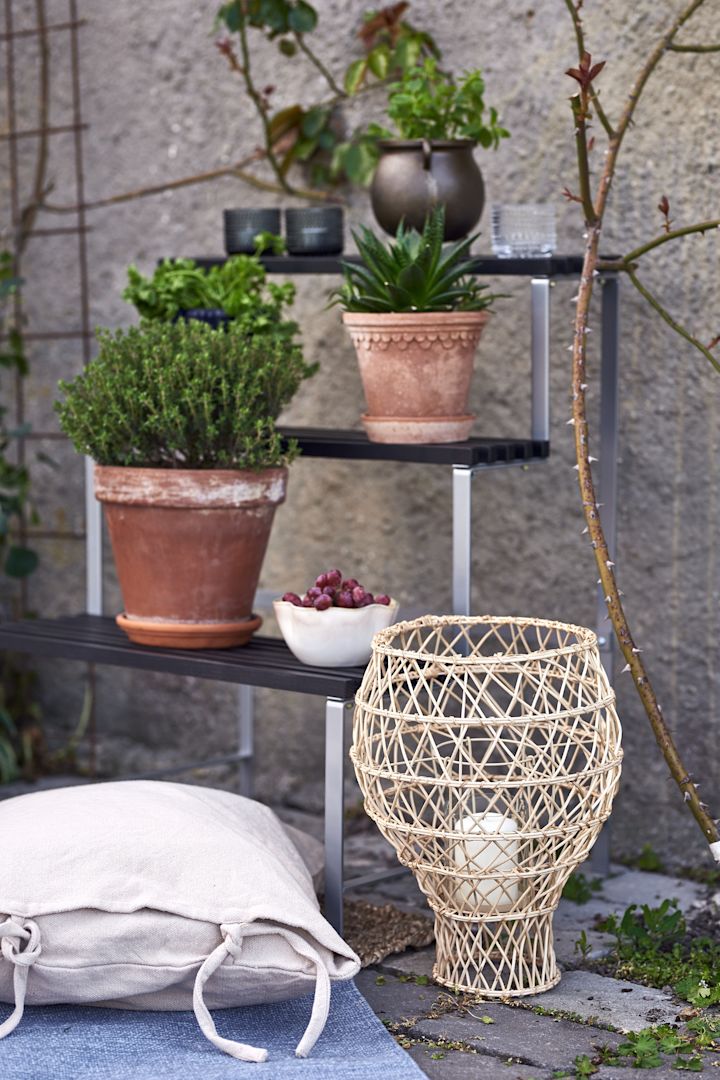 Tipps für einen Balkon im Boho Style – neben Blumentöpfen aus Terrakotta sticht der Fruchtkorb von Urban Nature aus Rattan hervor.