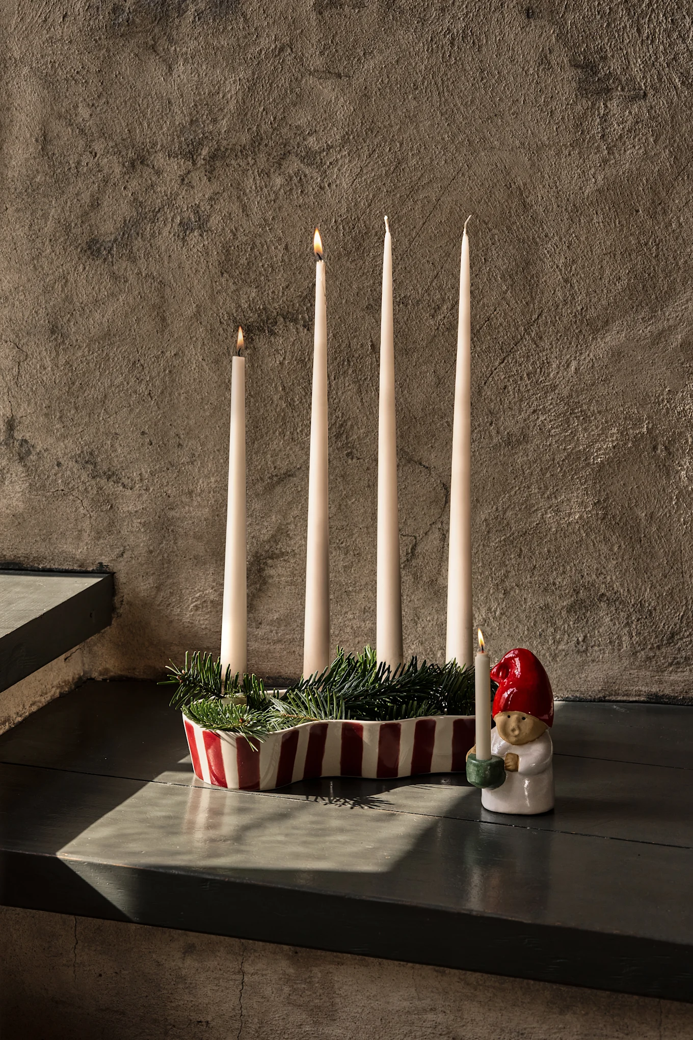 Eleganter Tisch mit dunkelroter Decke, Weingläsern, Tellern, einer Obstetagere und Kerzen.