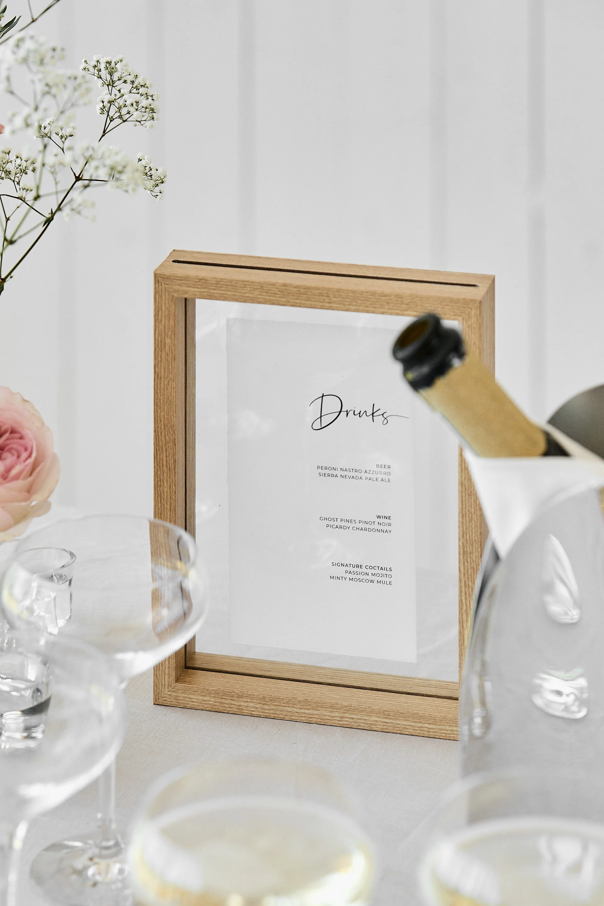 Eine einzigartige Hochzeitsidee, ideal für Hochzeiten im Freien. Hier sehen Sie eine Nahaufnahme einer Getränkekarte in einem Holzrahmen von Urban Nature Culture.
