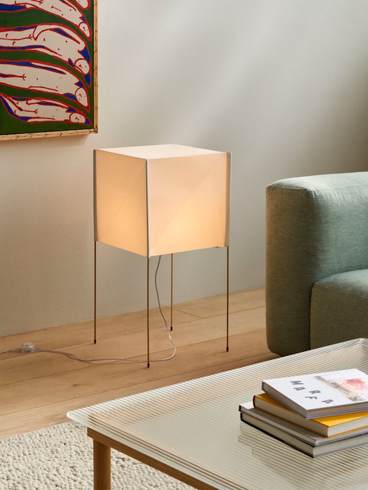 Lampen mit Papierschirmen liegen im Herbst 2025 im Trend. Hier steht die quadratische Paper Cube Stehleuchte von Hay in einem Wohnzimmer.