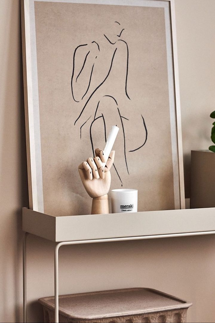 Eine beigefarbene Plant Box von Ferm Living, die mit dem beigefarbenen Poster Grace von Paper Collective dekoriert wurde.