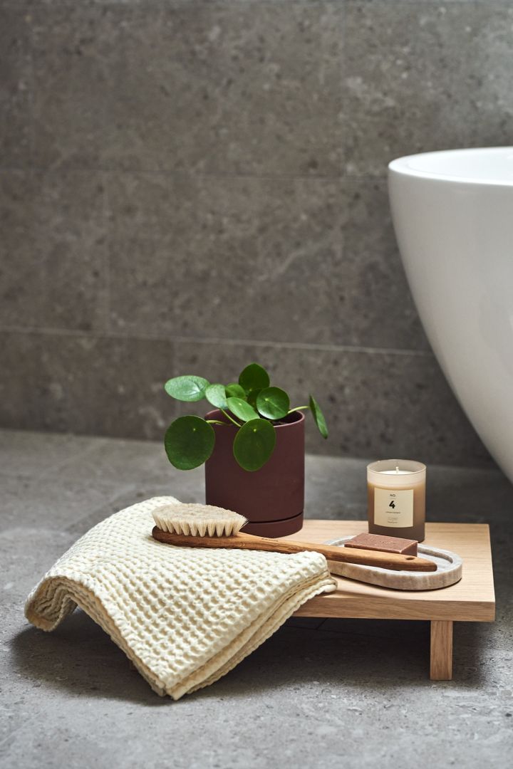 Badezimmer im japanischen Stil mit dem Kano Beistelltisch von Ferm Living, braunem Blumentopf und Spaten-Details.