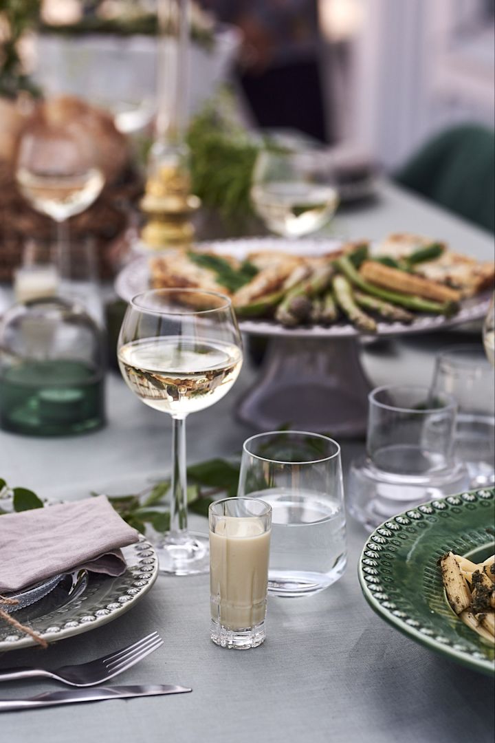 Glänzende Glaswaren von Rosendahl Copenhagen und Iittala kontrastieren bei dieser grünen Gartenparty mit dem Steingut-Porzellan. 