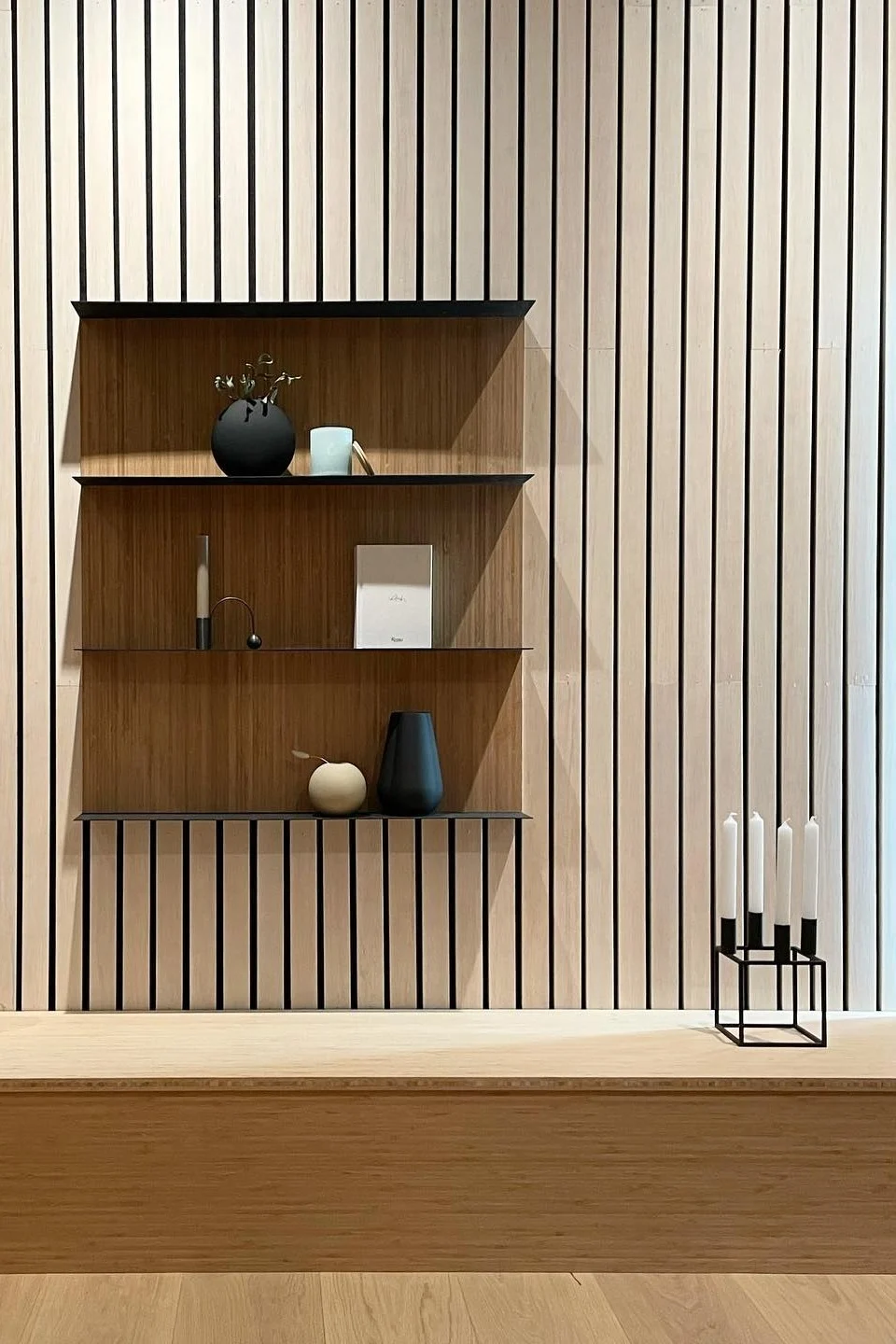 Japandi: Hier sehen Sie ein Wandregal, dekoriert mit dem Kubus Kerzenhalter von Audo Copenhagen, dem Balance-Kerzenhalter von ferm LIVING und der Ball-Vase von Cooee Design.