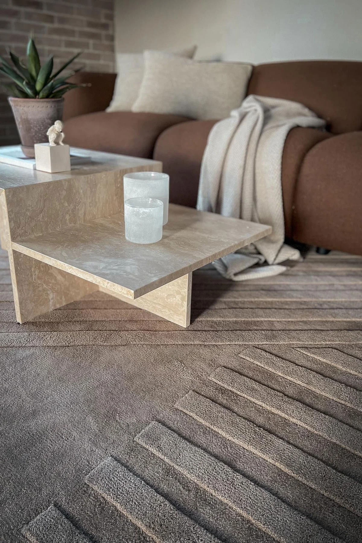 Das beigefarbene Wohnzimmer von @villanyhus, mit dem beigefarbenen Levels Wollteppich von NJRD, dem Distinct Couchtisch und einem braunen Sofa.