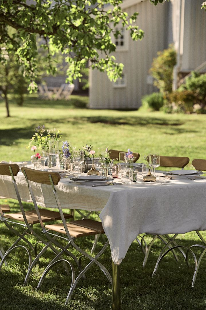 Mittsommer 2025: Hier sehen Sie einen fürs schwedische Mittsommerfest dekorierten Tisch im Garten.