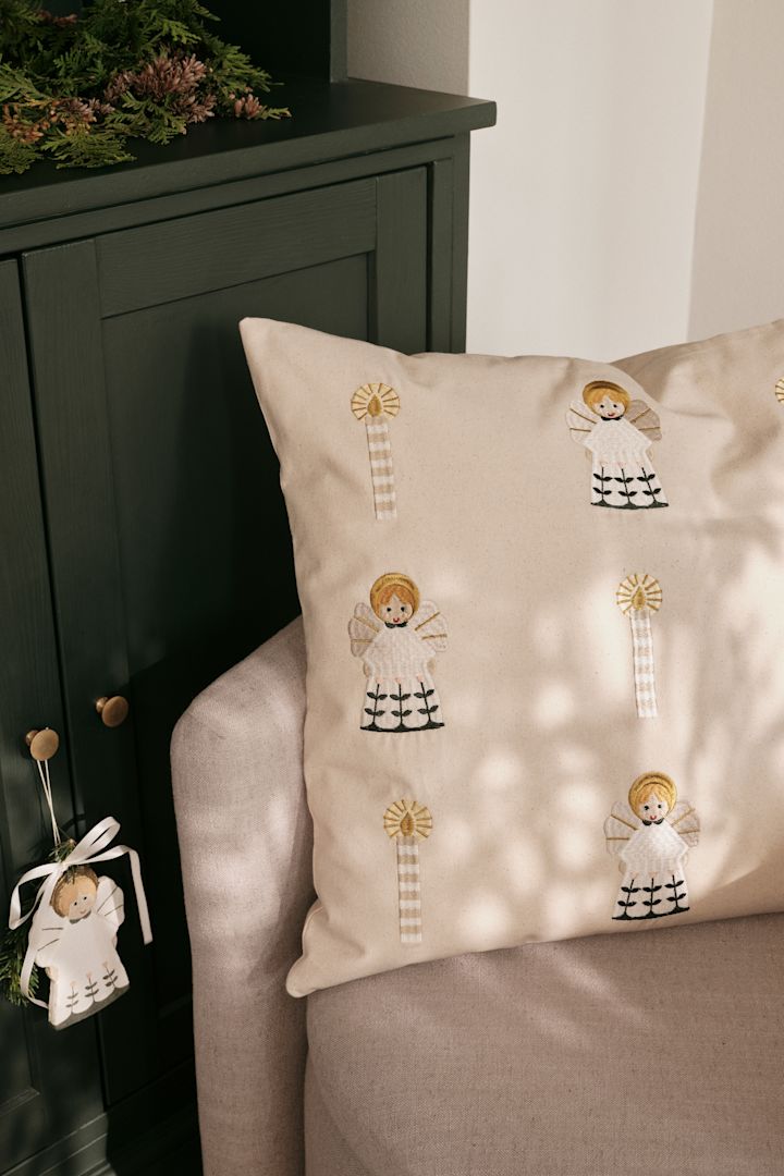 Weihnachtskissen erfeuen sich auch in Skandinavien großer Beliebtheit. Hier steht das goldene Fairy Tale Kissen von Broste Copenhagen auf einer Couch.