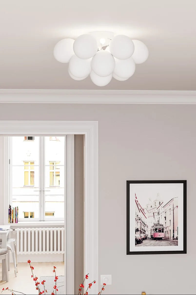 Die Gross-Deckenlampe von By Rydens hängt in einem hell eingerichteten Wohnzimmer.