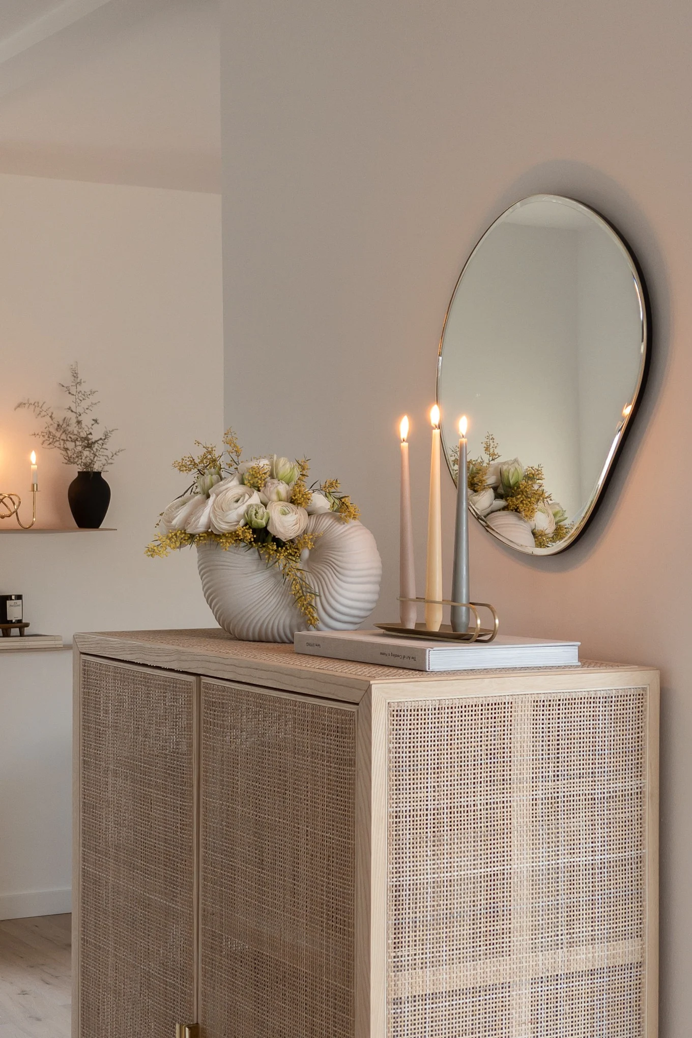 Kreieren Sie ein skandinavisches Zuhause mit @haus_tannenkamp. Hier sehen Sie einen Rattanschrank mit dem Pond Spiegel und dem Shell pot, beides von ferm LIVING.
