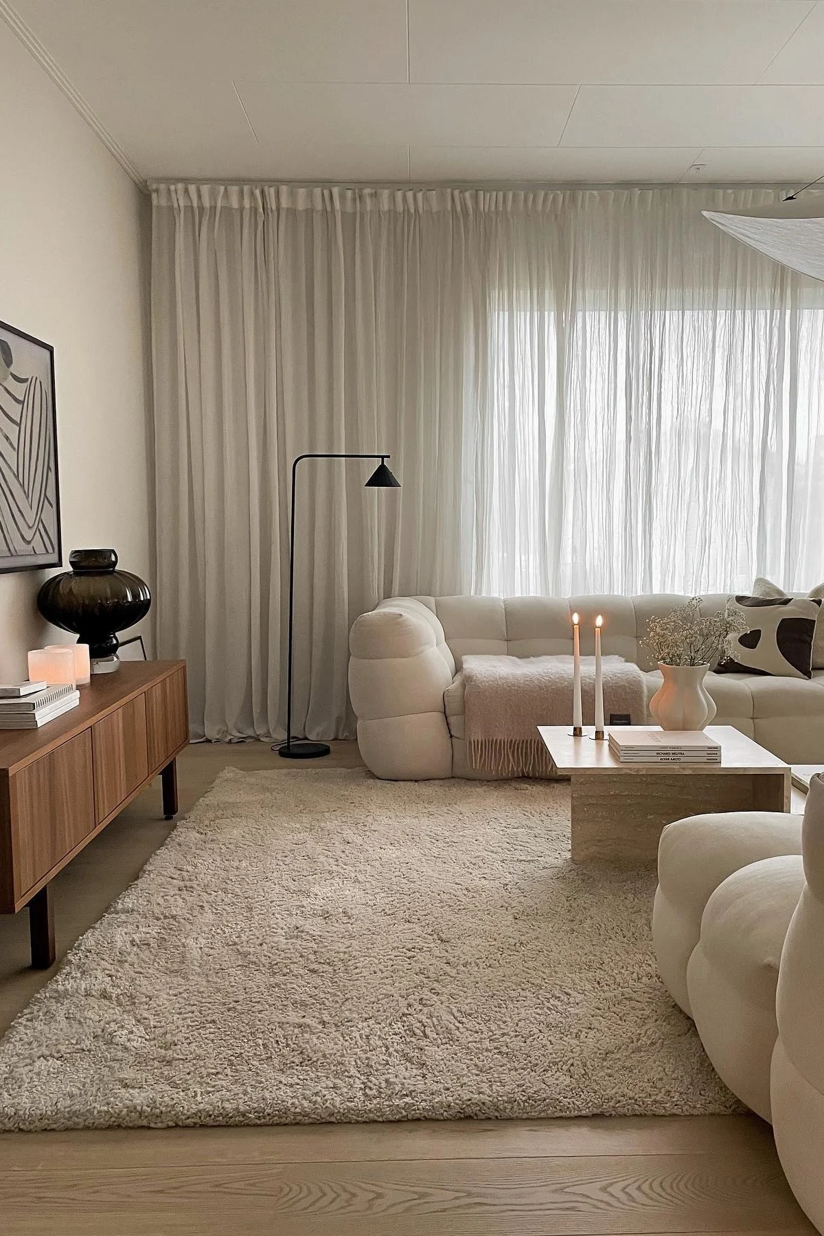 Das beigefarbene Wohnzimmer von @joanna.avento mit großem beigefarbenen Teppich, heller Couch und dem Distinct Couchtisch von Ferm Living.