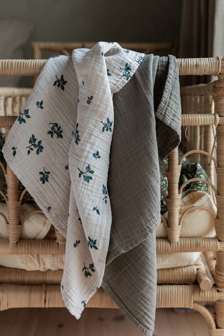 Die Blueberry Muslin Decken von Garbo&Friends, welche hier über einem Bett-Geländer hängen, eignen sich nicht nur als Kuschel- sondern auch als Spucktuch, was sie zu einem praktischen Geschenk zur Babyparty macht.