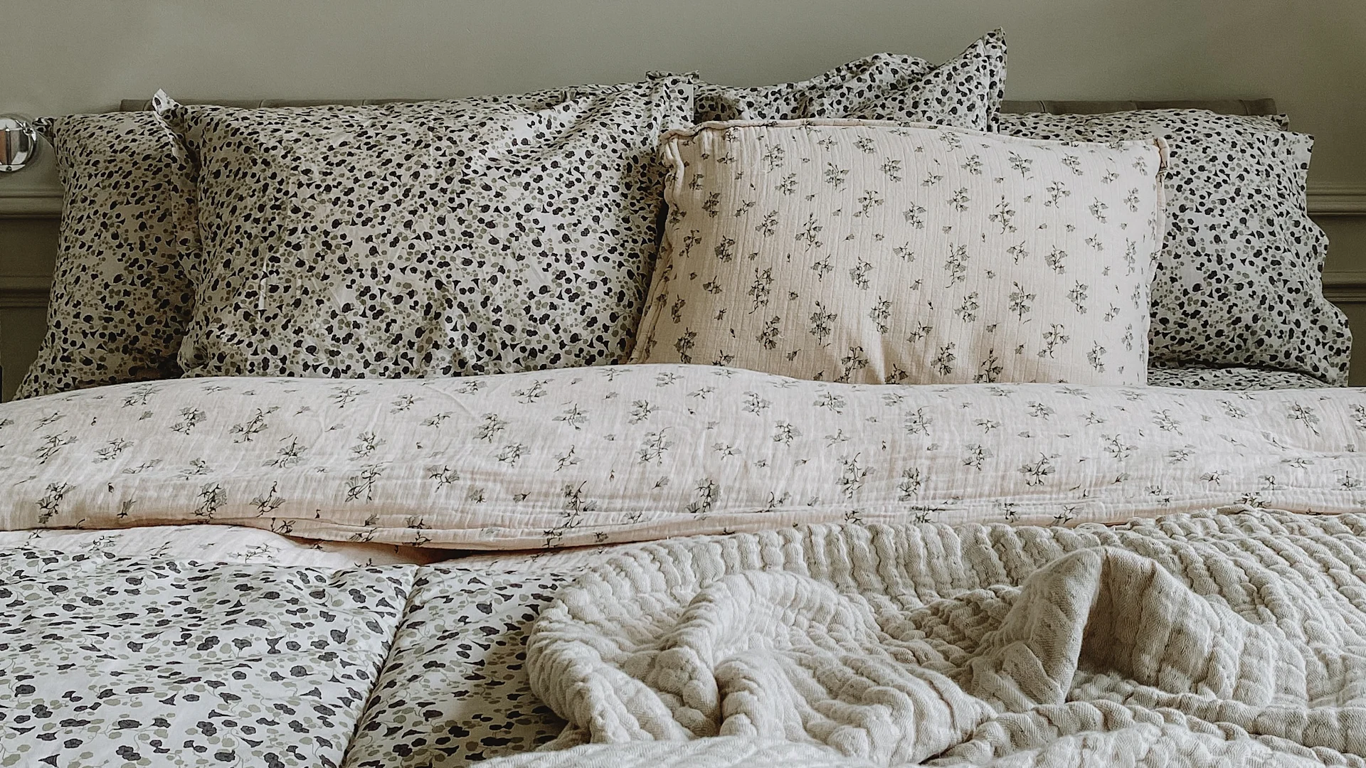 Eine weiche und kuschelige Bettgarnitur eignet sich perfekt als Hochzeitsgeschenk-Idee für ein schönes Schlafzimmer und besonders guten Schlaf. Hier sehen Sie die geblümten Bettbezüge von Garbo & Friends in einem grünen Schlafzimmer.