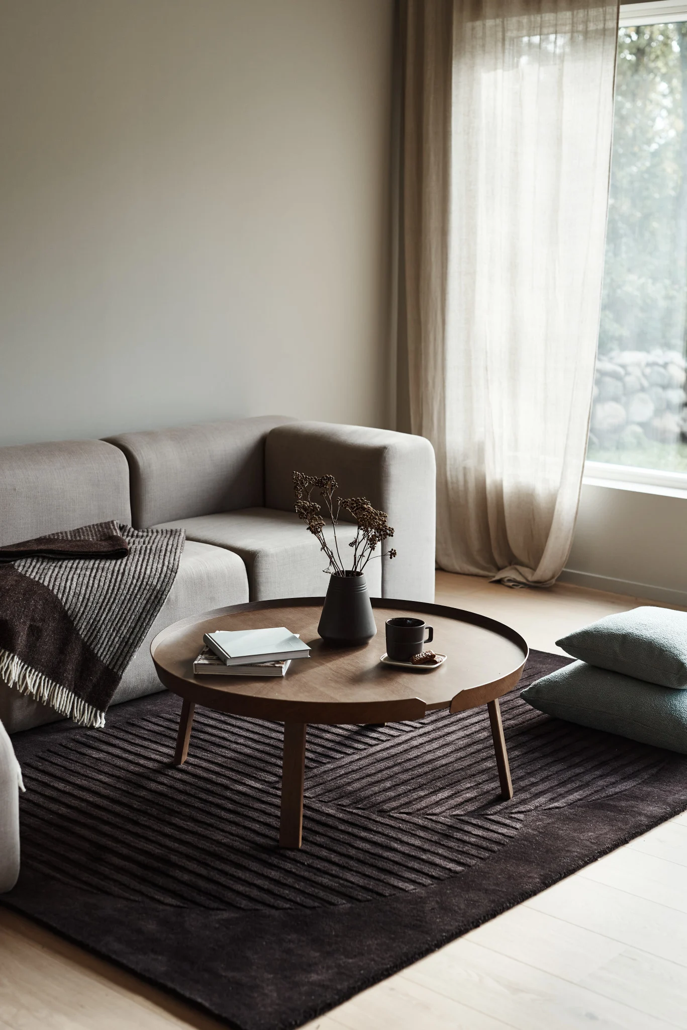 Der Levels Wollteppich in braun von NJRD verleiht Ihrem Wohnzimmer eine kuschelige und angenehme Atmosphäre.