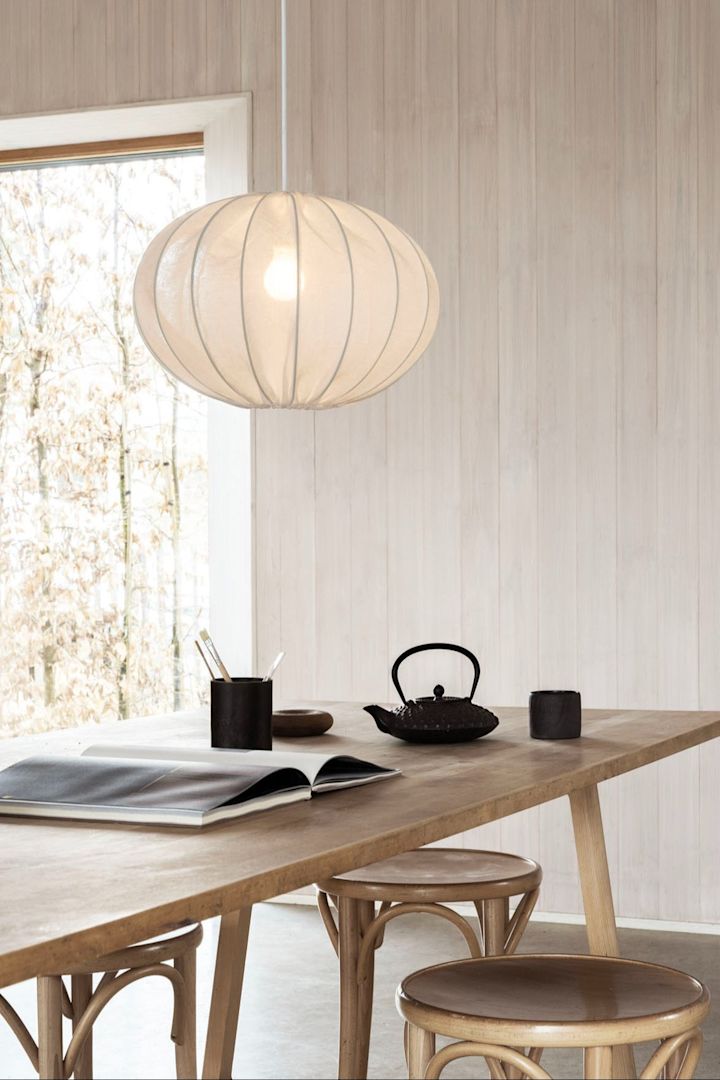 Der Boll Lampenschirm aus Leinen von Watt & Veke eignet sich perfekt für die Einrichtung im Japandi-Stil und hängt hier über einem hohen Tisch mit Barhockern.