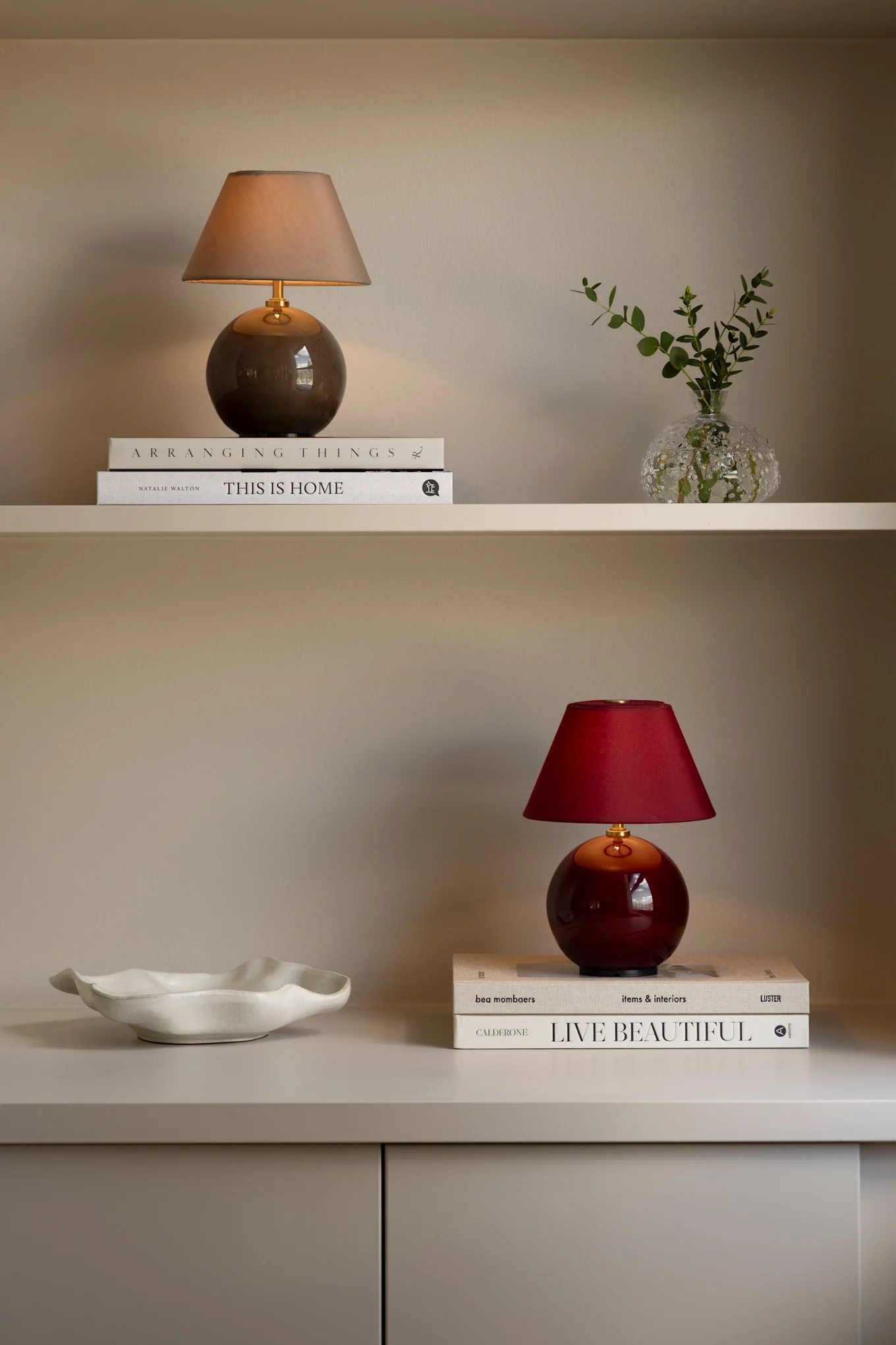 Zwei wiederaufladbare Iris 16-Lampen in Rot und Braun stehen zusammen mit Büchern in einem Bücherregal.