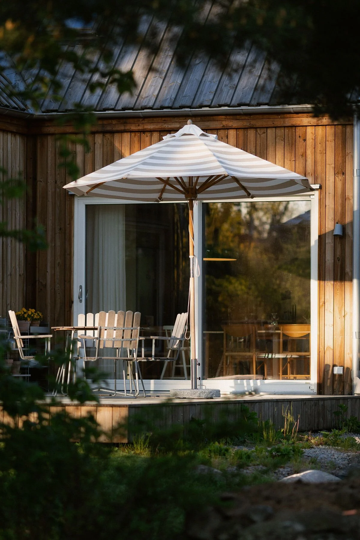 Der Hisshult Sonnenschirm von 1898 steht vor dem Holzhaus und auf der Terrasse von @applauden, daneben eine Sitzgruppe von Grythyttan.