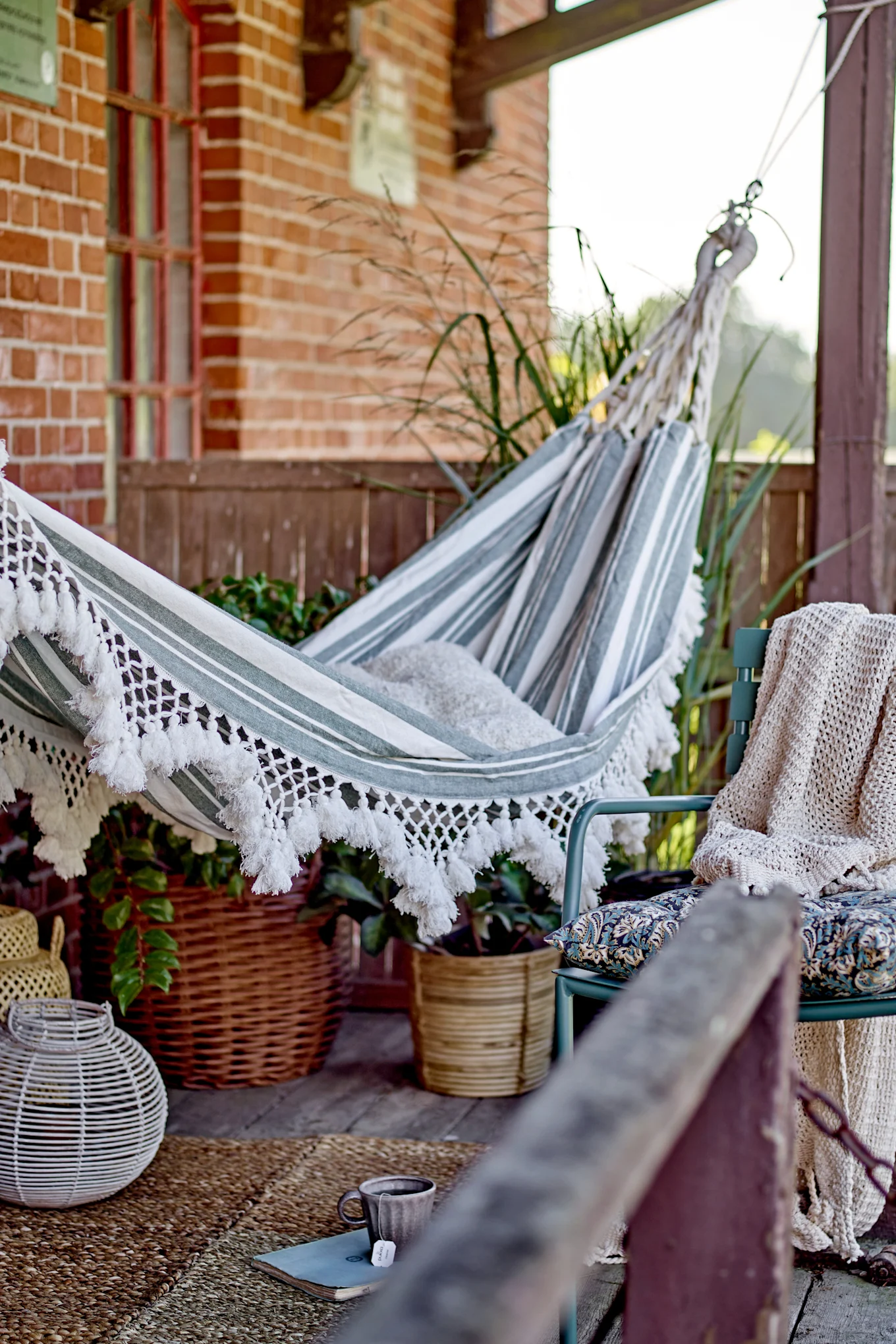 Boho-Balkon dekorieren: Die Cruz-Hängematte von Bloomingville hängt auf einem im Boho-Stil eingerichteten Balkon.