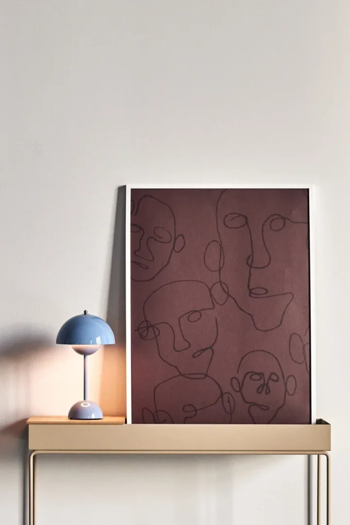 17 stilvolle Poster zur Dekoration Ihres Zuhauses - hier das Audience-Poster von Paper Collective mit mehreren Gesichtern auf dunkelbraunem Grund.