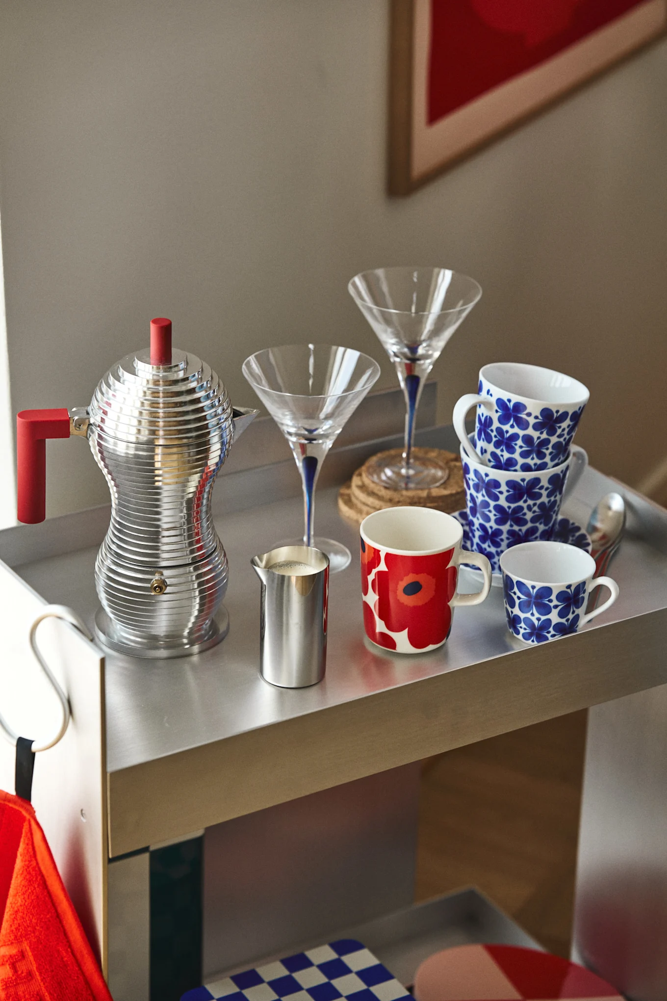 Hier sehen Sie einen Kaffeewagen mit dem Espressokocher von Alessi, Mon Ami Tasse von Rörstrand und einer Unikko Tasse von Marimekko.