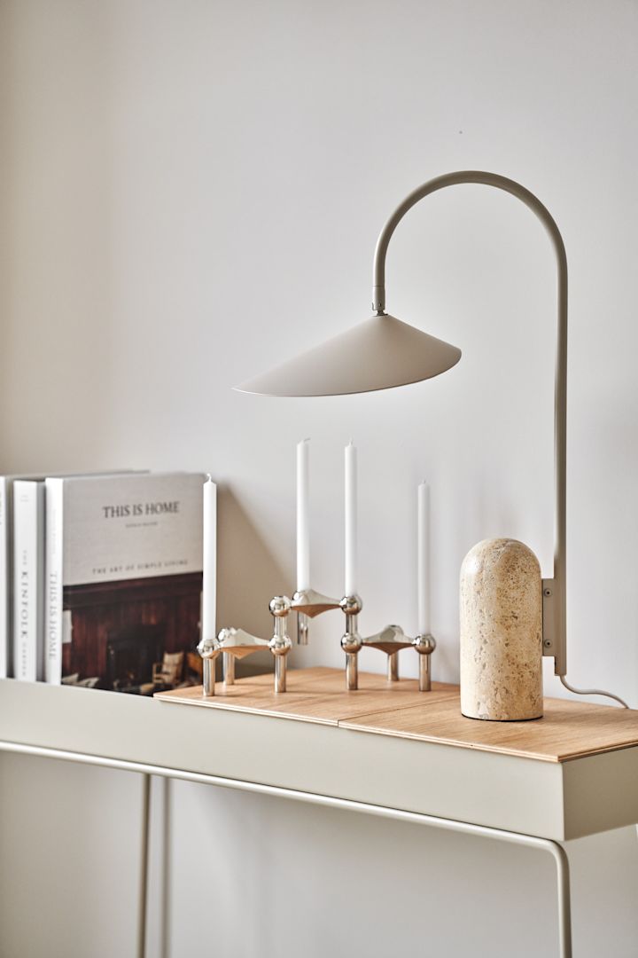 Dekorieren Sie Ihr Wohnzimmer mit beigen Möbeln, um einen stilvollen Look in Ihrem Zuhause zu schaffen. Hier sehen Sie den vielseitigen Plant Box Konsolentisch von Ferm Living zusammen mit dem Kerzenständer Stoff Nagel und der Tischleuchte Arum in stilvollen Beigetönen.