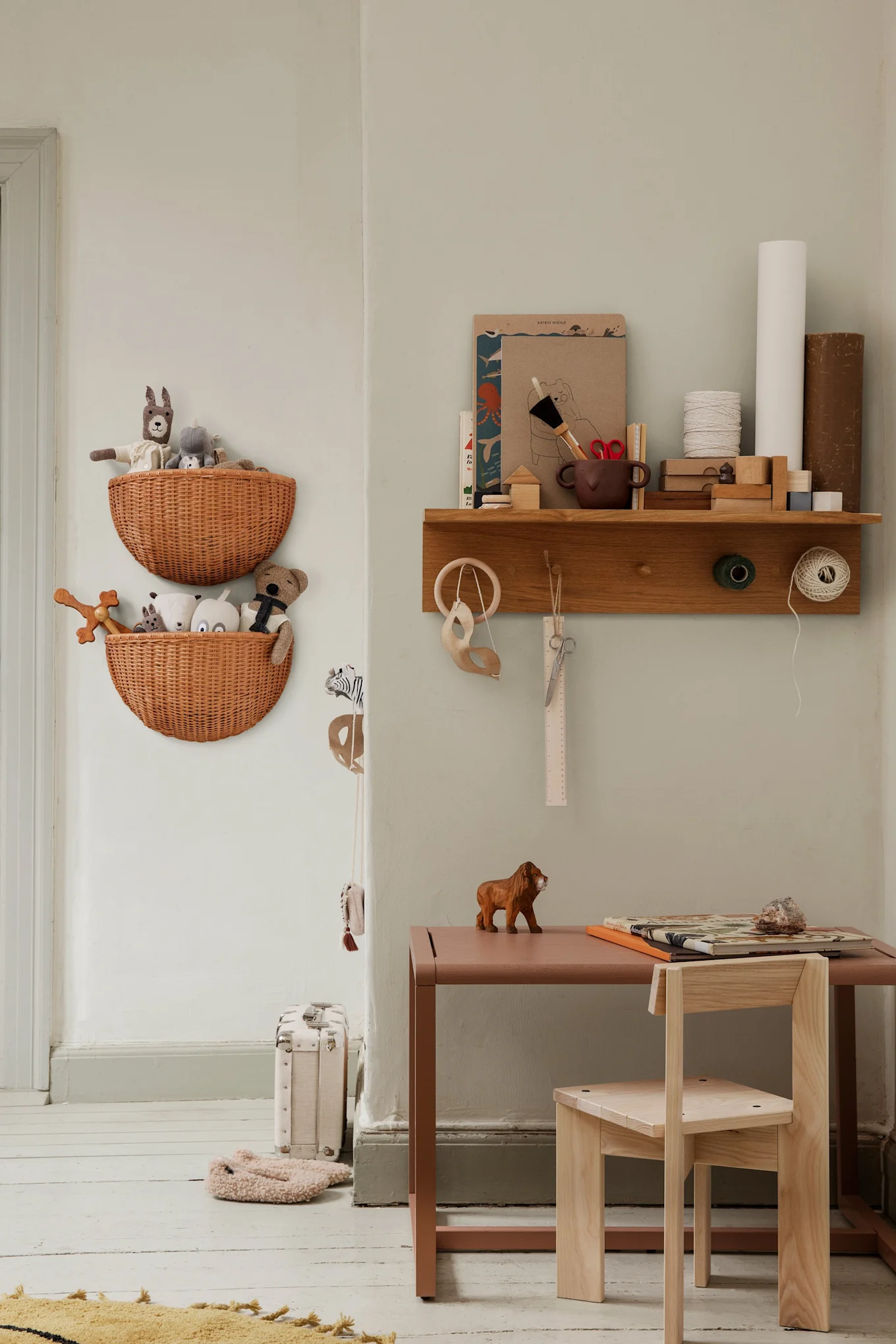 Entdecken Sie, wie Sie Ihr Zuhause aufräumen können. Hier sehen Sie die Körbe und Haken von Ferm Living mit einem Regal, das an der Wand im Kinderzimmer hängt.