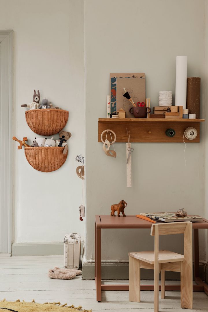 Entdecken Sie, wie Sie Ihr Zuhause aufräumen können. Hier sehen Sie die Körbe und Haken von Ferm Living mit einem Regal, das an der Wand im Kinderzimmer hängt.