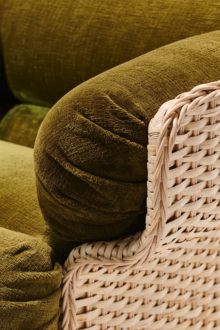 Klobige Möbel sind im Herbst 2025 im Trend. Der Korbstuhl von Gubi besteht aus einem Rattan-Korpus und dicken grünen Kissen.